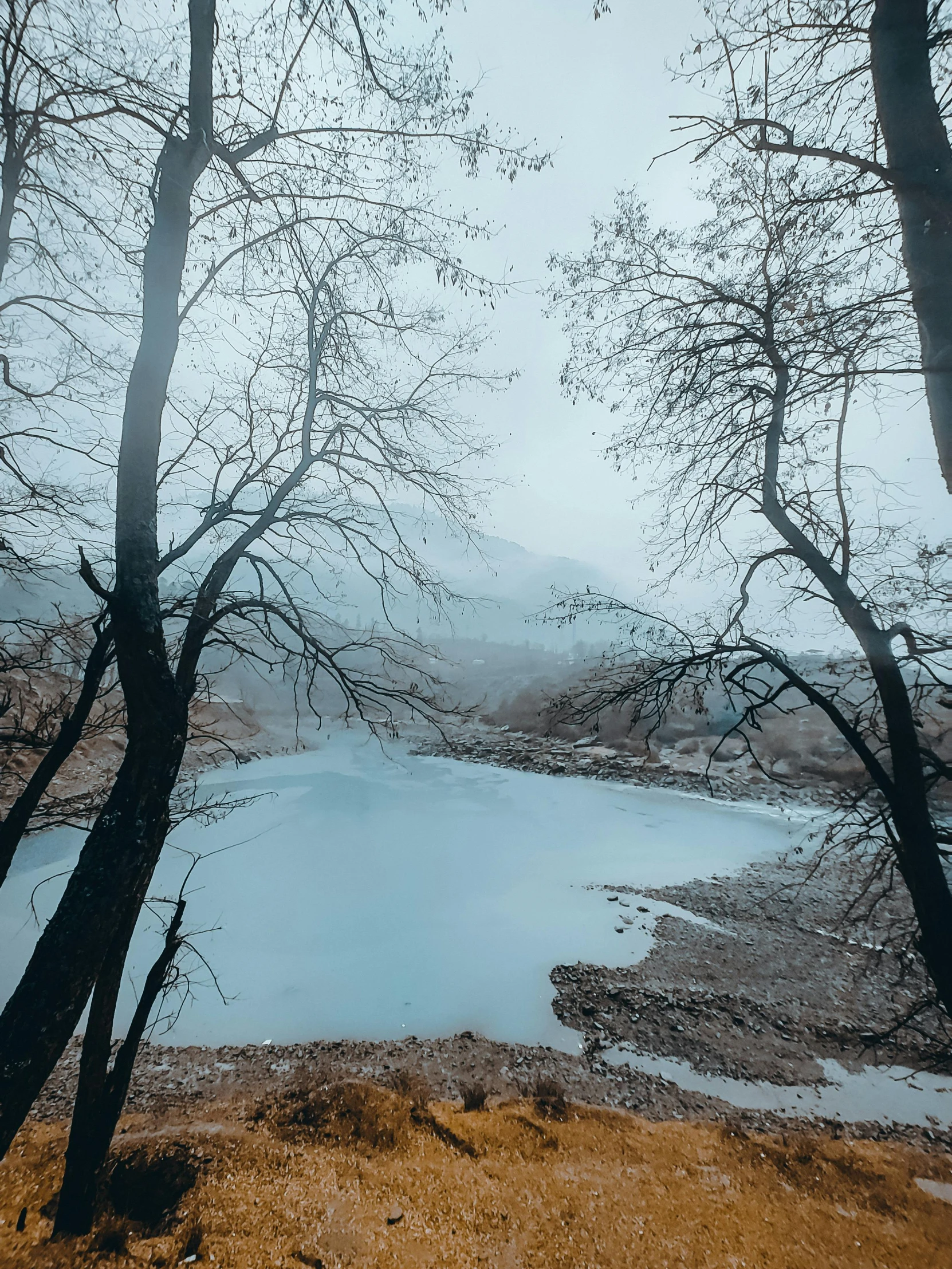 view from the top of a hill over a lake