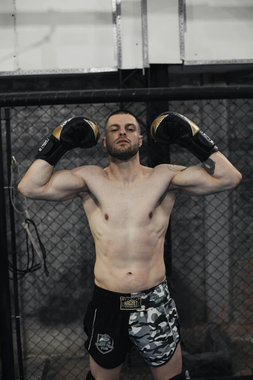 man standing in a caged in area wearing boxing shorts