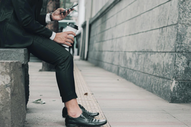 a man sitting on a bench and looking at his cell phone