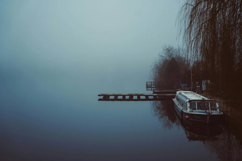 the boat is sitting on the still lake waters