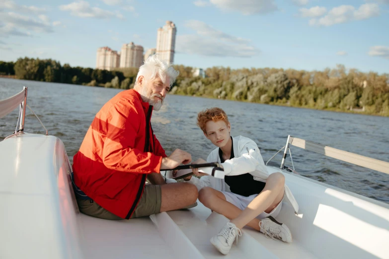 an older gentleman and a young child sitting on the back of a boat