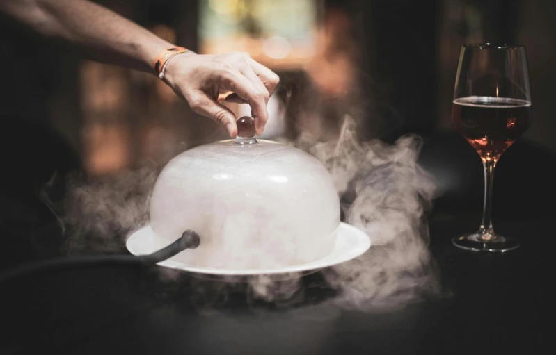 a man in a gray shirt is holding on to a silver dish with a white saucer