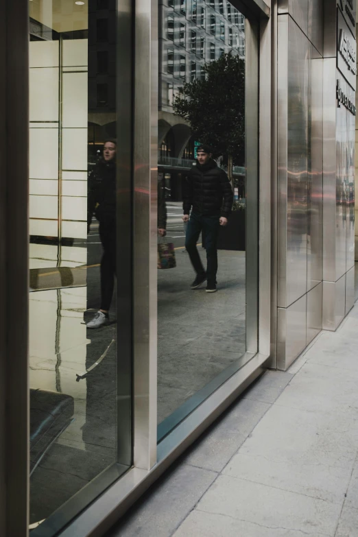 a large mirror reflects a man with a dog on a city sidewalk