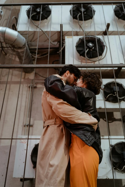 a young couple is emcing each other and standing in front of a window