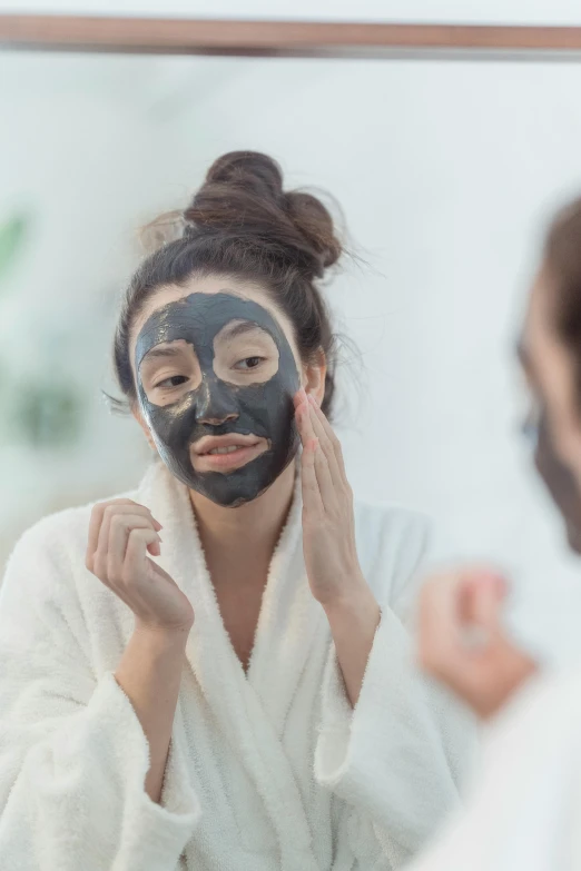 a woman wearing a mask on her face while she brushes her teeth