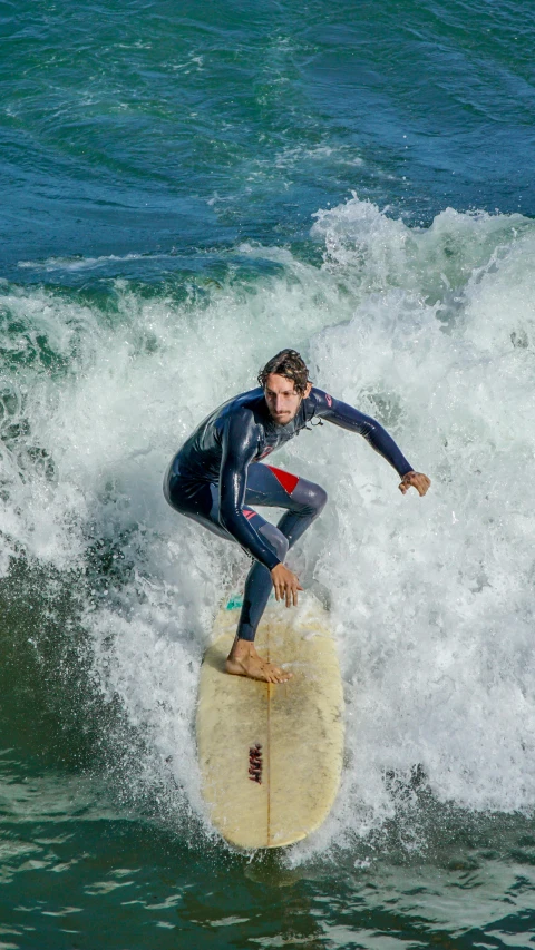 a man in a wet suit riding on top of a wave