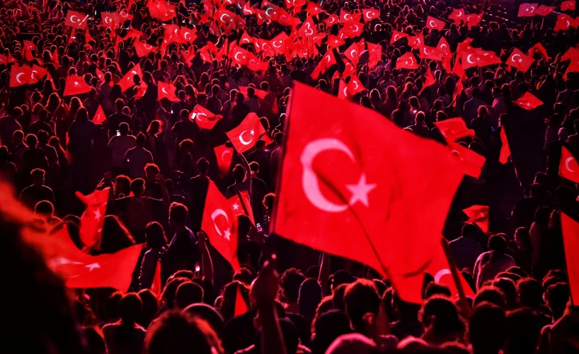 many people are gathered together and there is a turkish flag flying