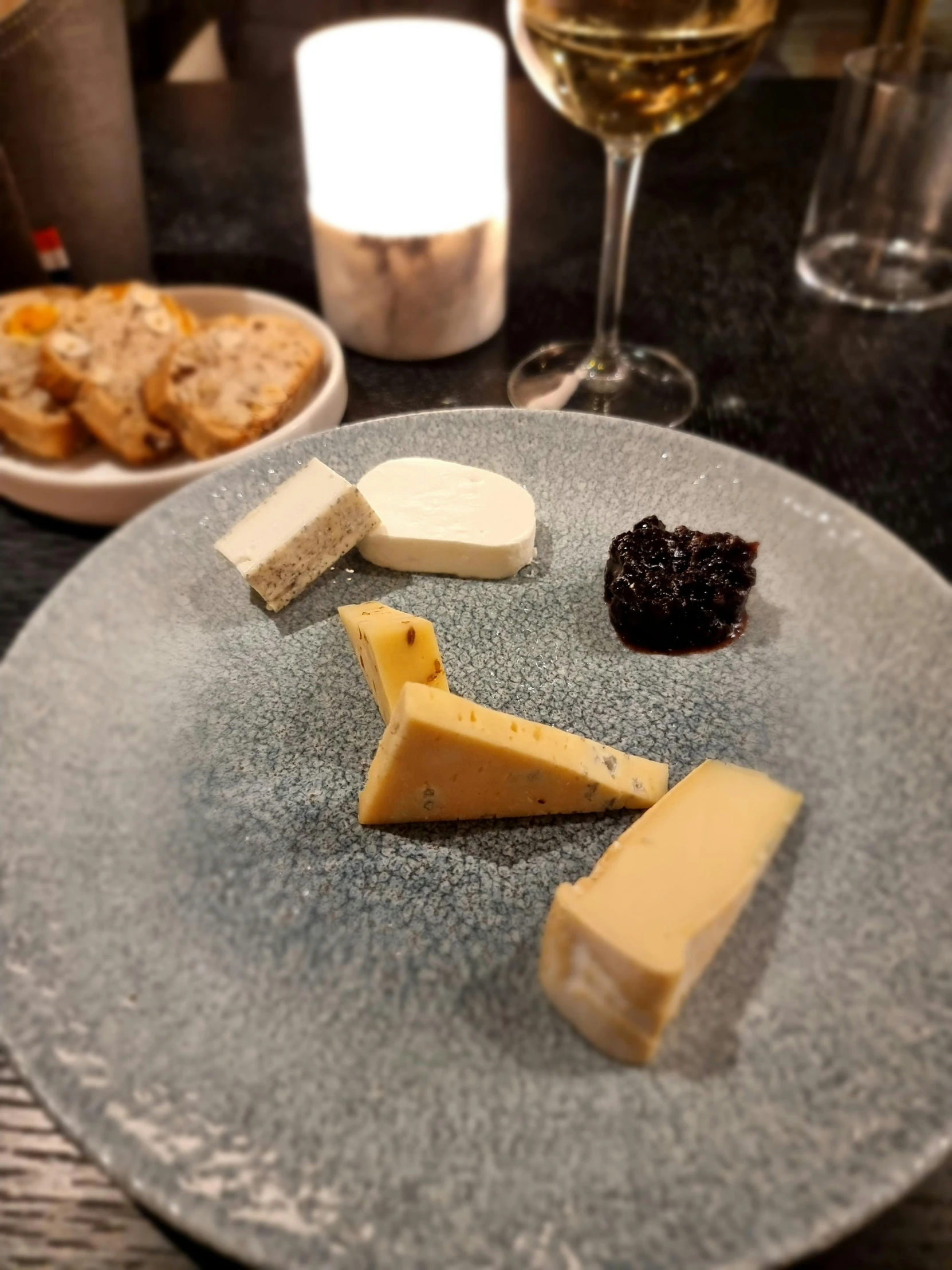 a plate with various cheeses and ers on it