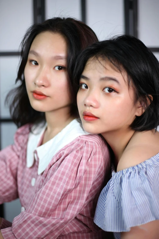 two asian women are posing for the camera