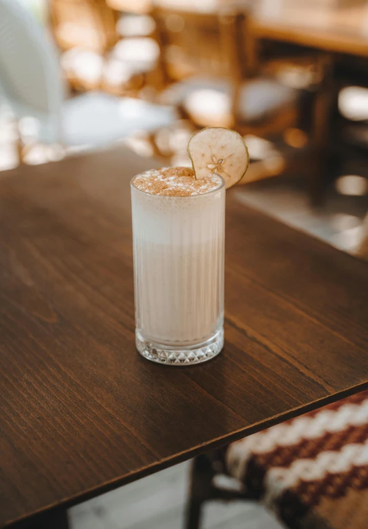 a drink on a table next to a brown chair