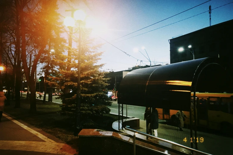 a long yellow bus traveling down a street near a building