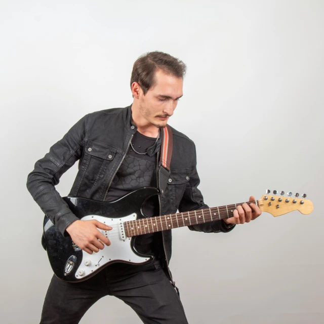 a person in black outfit playing an electric guitar