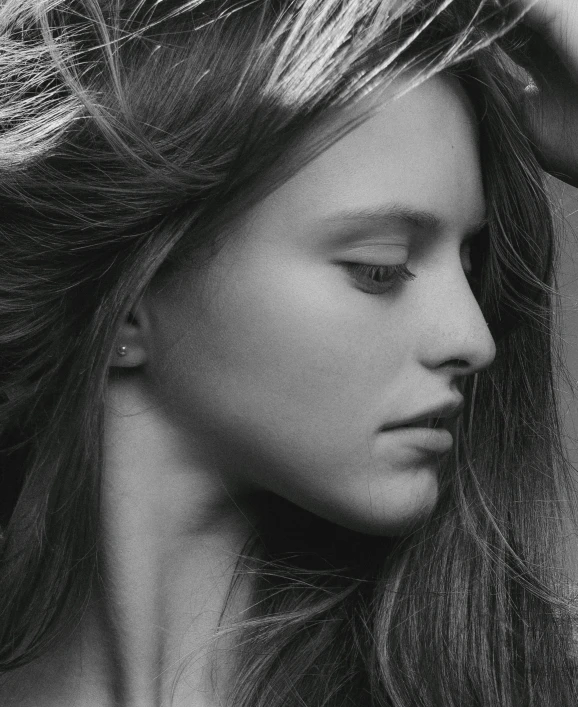 black and white image of a woman putting her hair