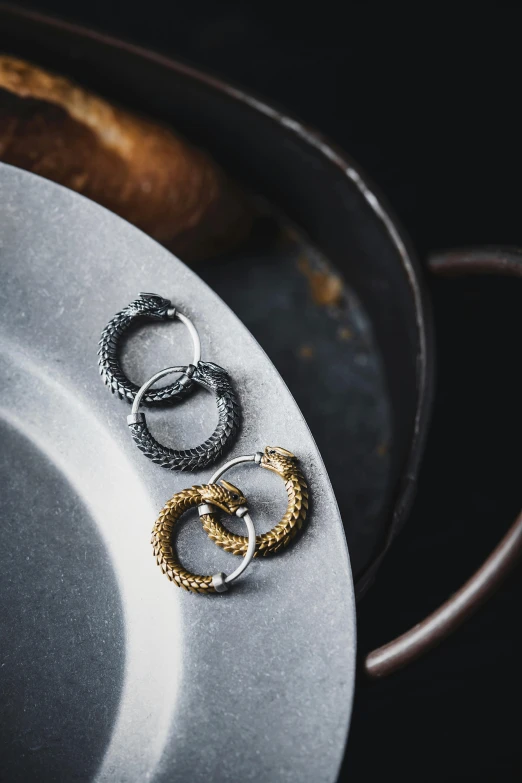 two rings are sitting on a plate next to some bread