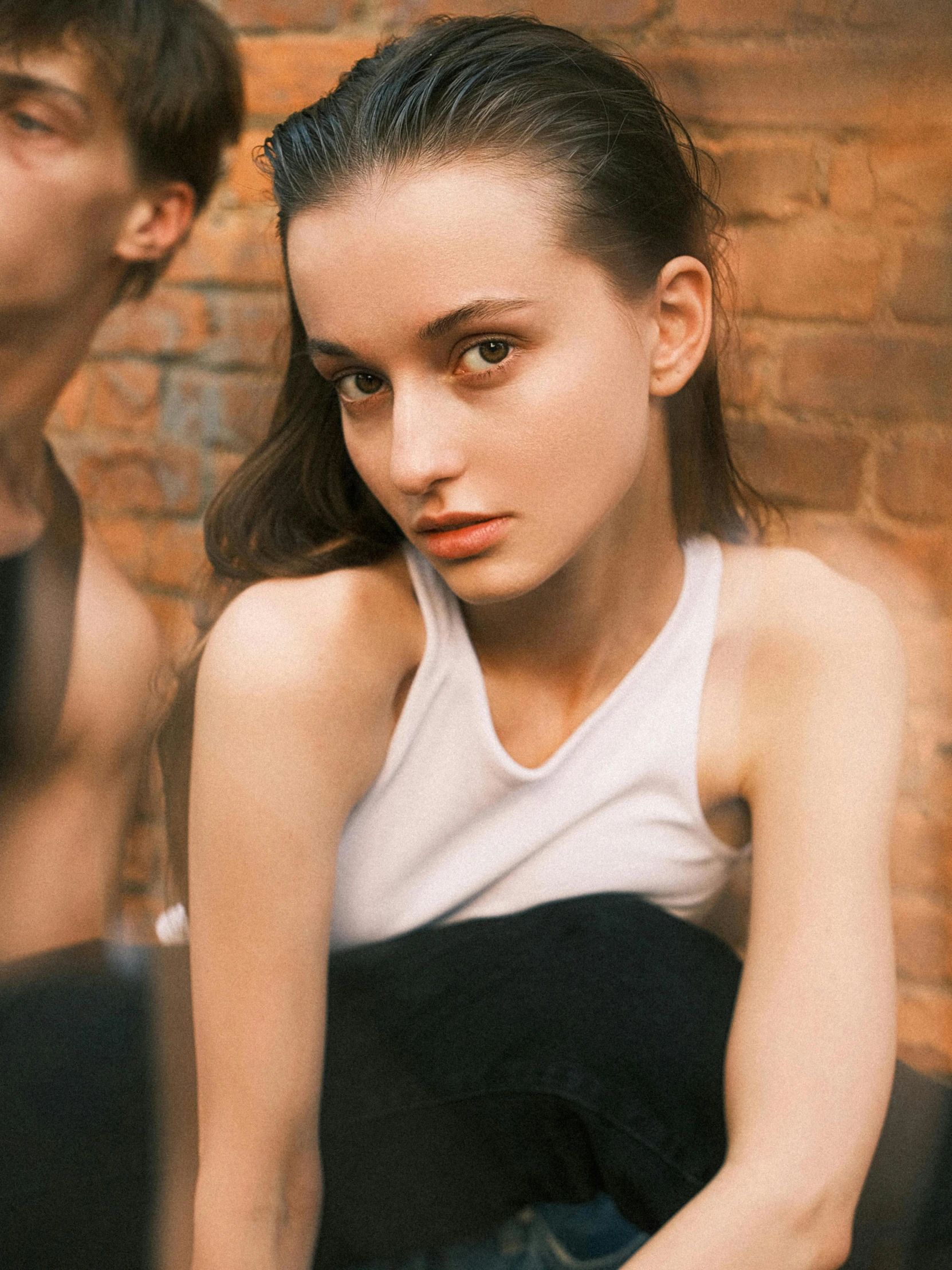 a young woman wearing a black top and a man sitting next to her