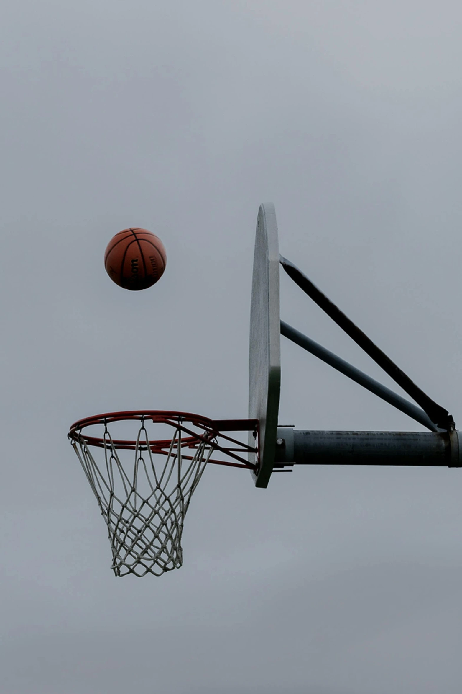 a basketball flying past a basketball hoop in the sky