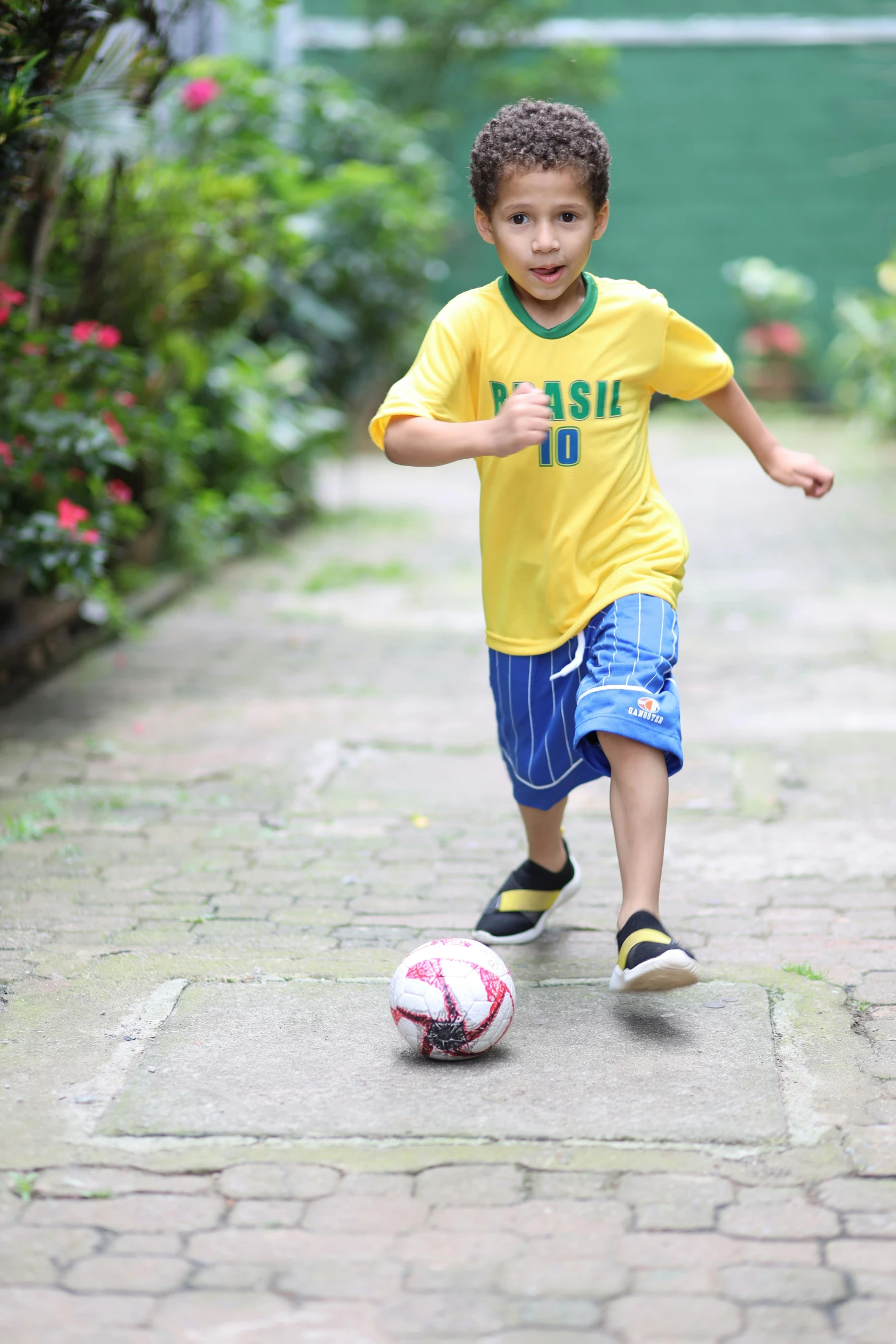  kicking soccer ball down a stone path