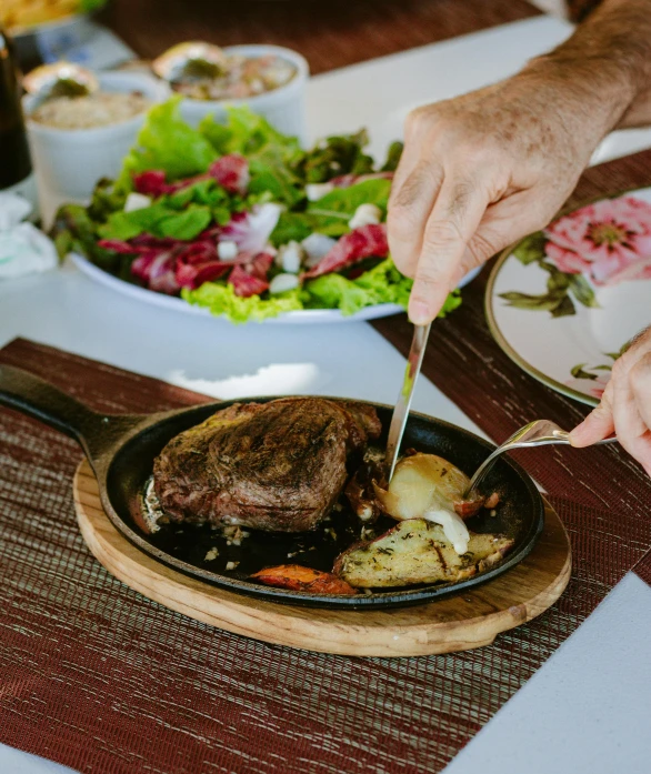 a person with their hands on a plate and chopping some food