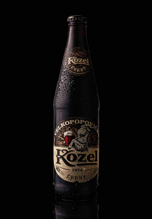 an empty bottle of beer sitting on a black surface