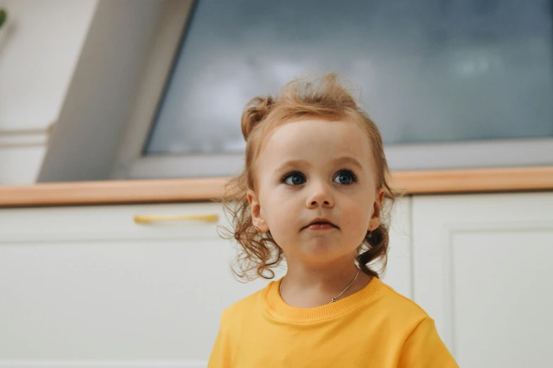 a  with curly hair standing in front of a door