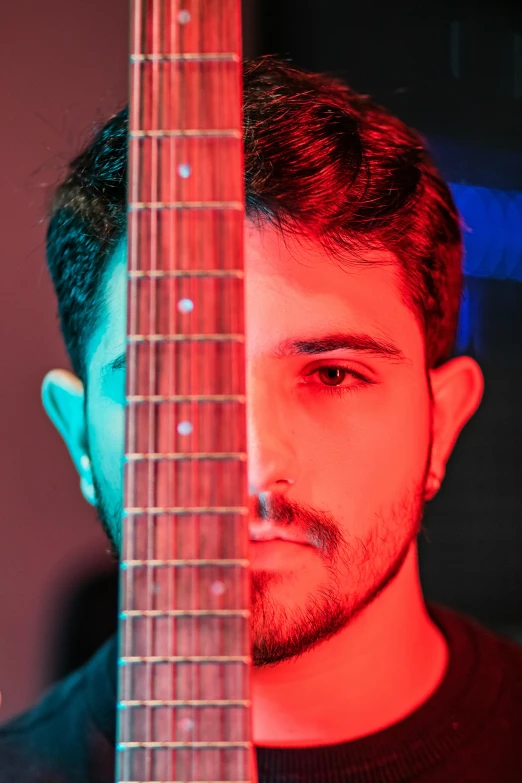 a man is holding the neck of his guitar