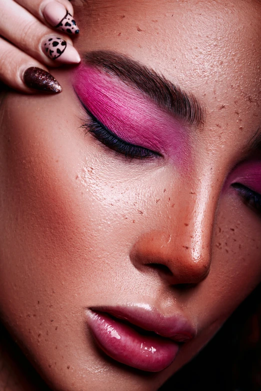 a woman is holding her hair down while posing with pink and gold makeup