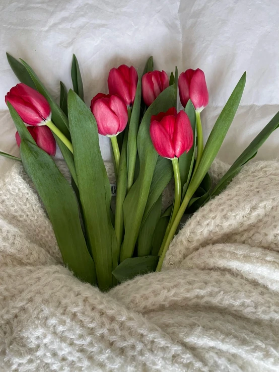 a bunch of pink flowers are sitting on the bed