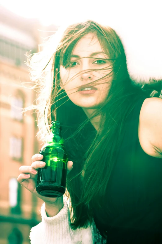 a young lady with a green bottle posing for the camera