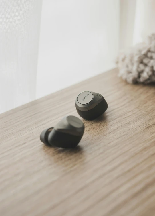 two rocks sitting on a wooden surface in front of a window