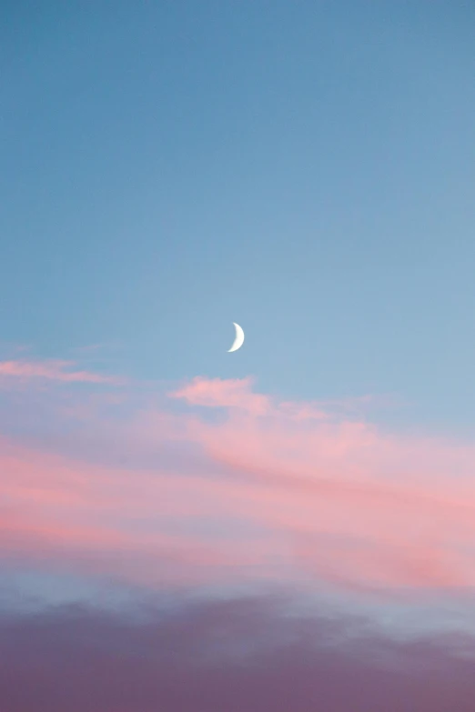 a blue and pink sky with the moon in the sky