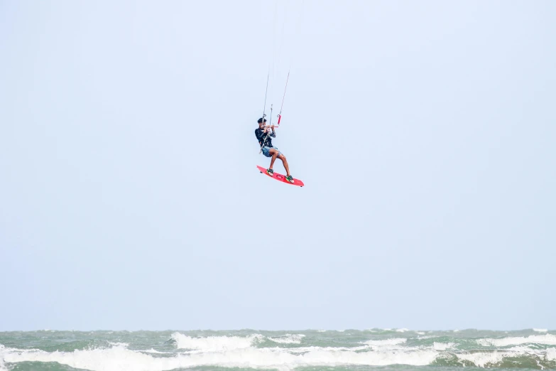 man water skiing in front of a very large wave