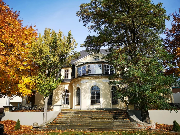 a mansion on a sunny autumn day with beautiful autumn leaves