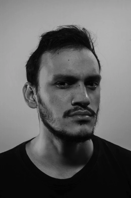 a man with a beard, black t - shirt and nose piercing