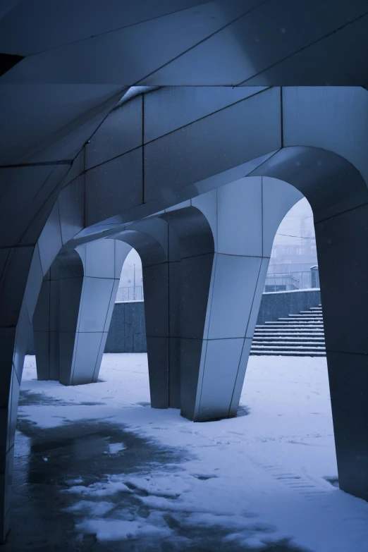 a group of arches sits in the snow near a stairway