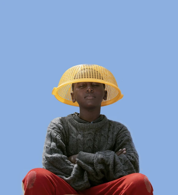 a black man with a yellow hat posing