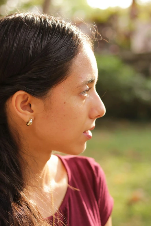 a woman wearing earrings looks to her left