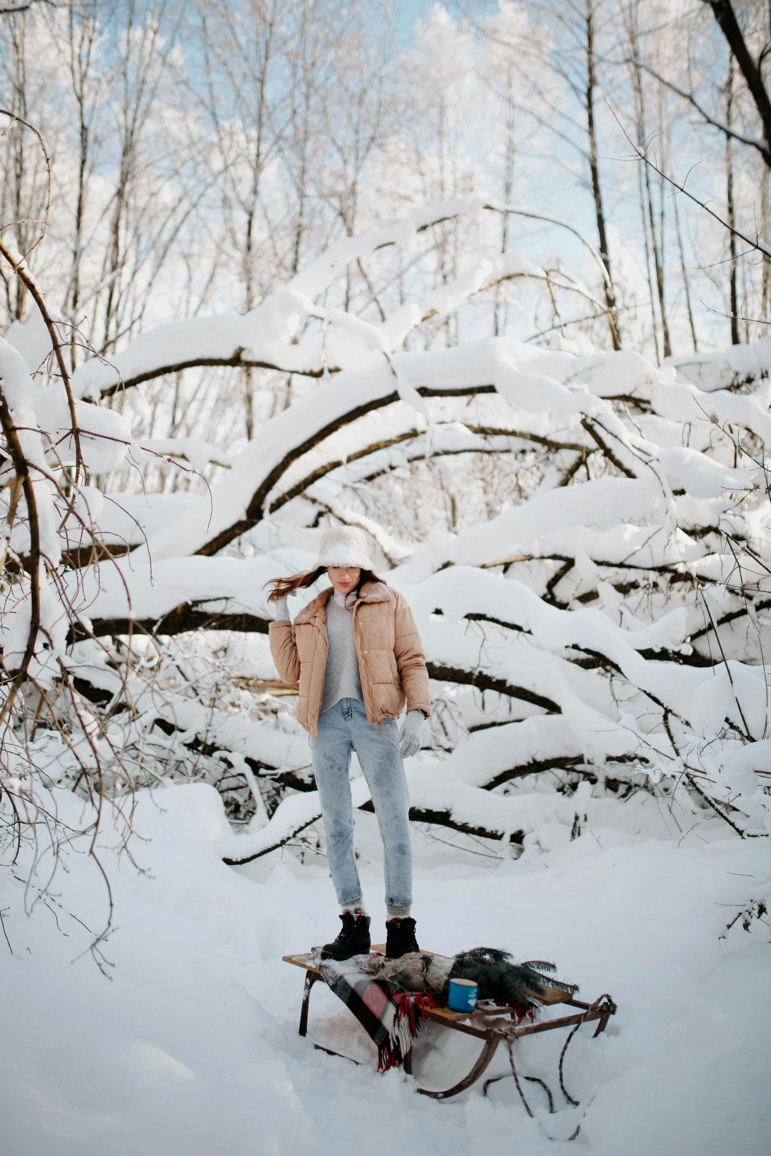 a man standing in the snow next to a sled