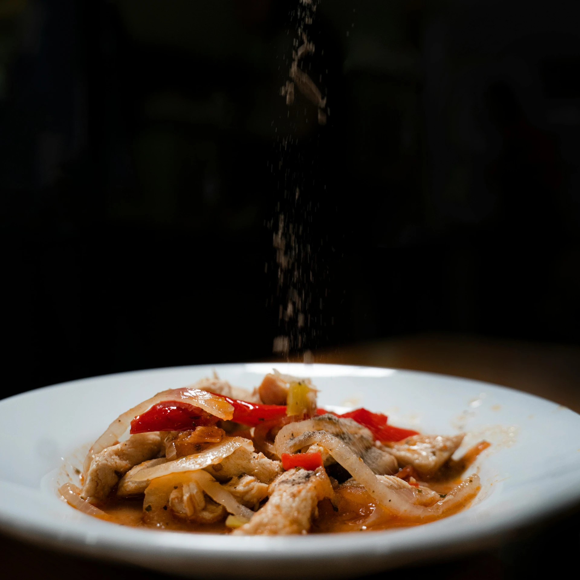 a bowl filled with rice topped with meat and peppers