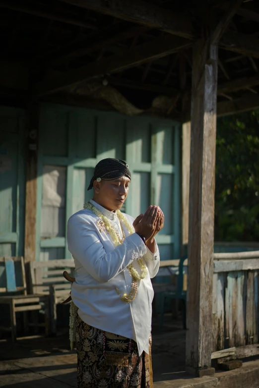 a woman standing outside in a long skirt holding her hands together