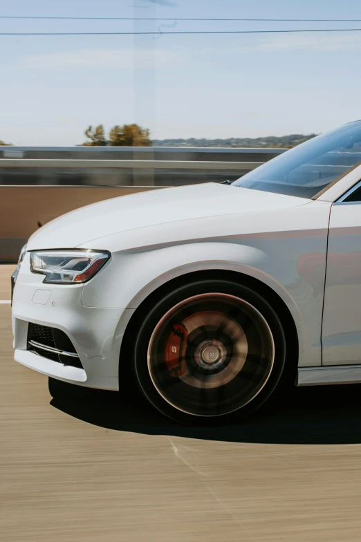 an all white car driving down the road