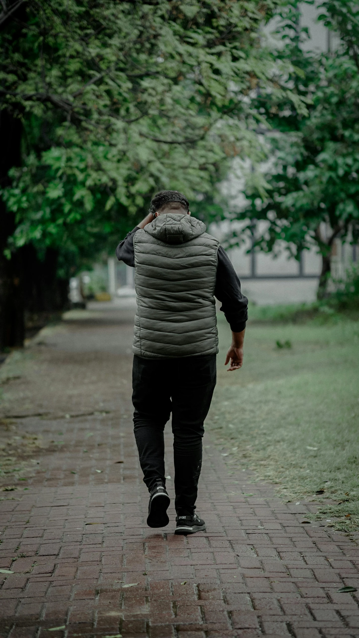 a man walking down a street next to trees