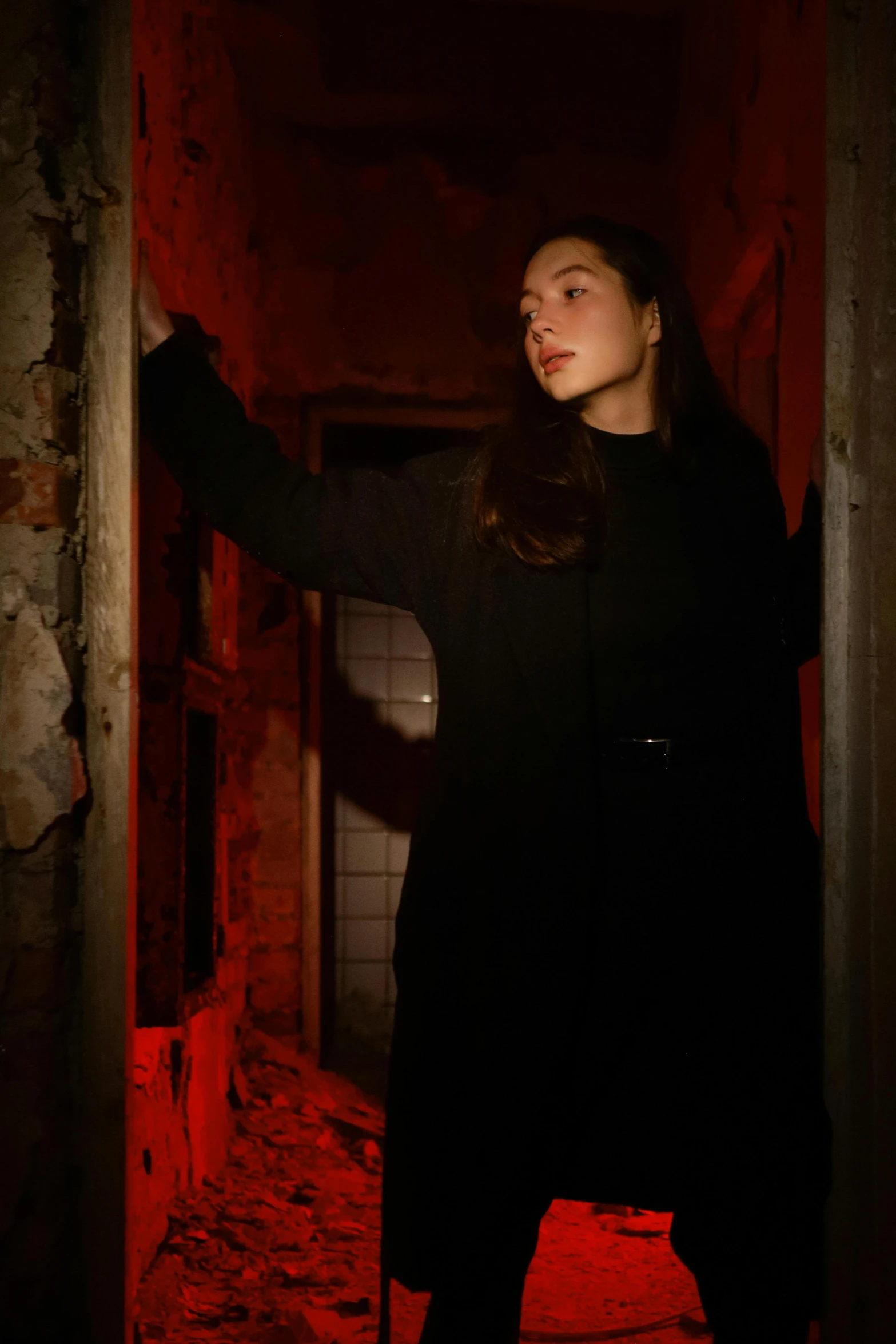 a woman standing in a doorway with a black coat