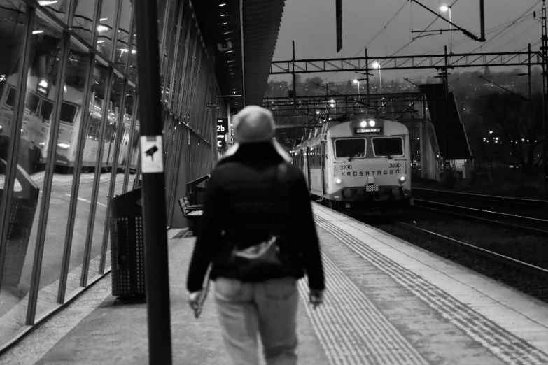 the man is waiting at the platform for the train to stop