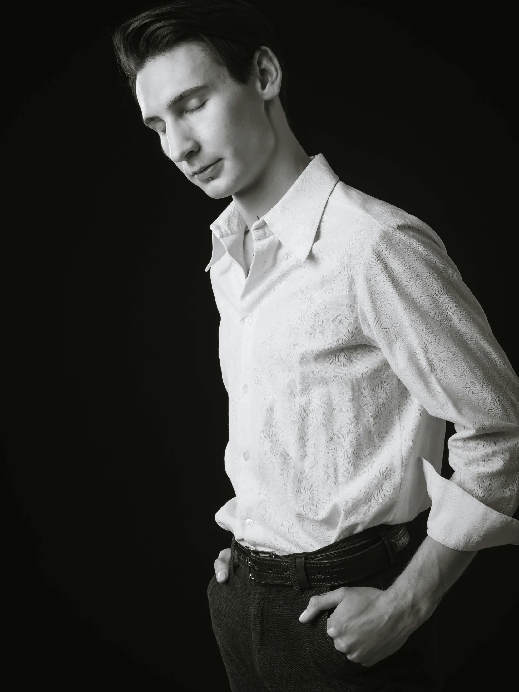 a man posing in a white shirt and pants