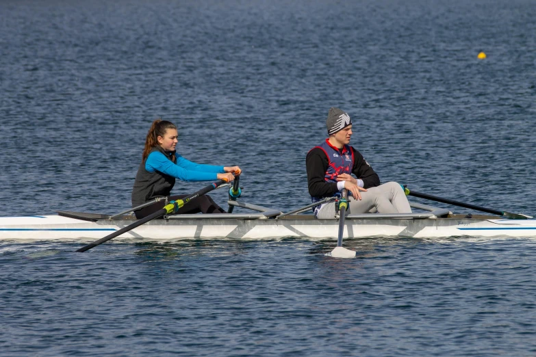 two people are sitting in a boat on the water