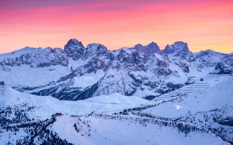 a red sky with the sun setting over the mountains in the distance