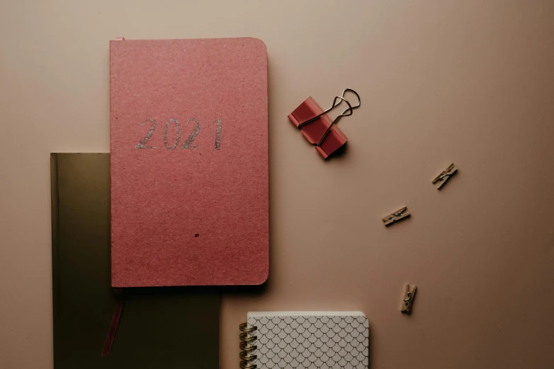 a pink book next to a notebook with the word blog written on it