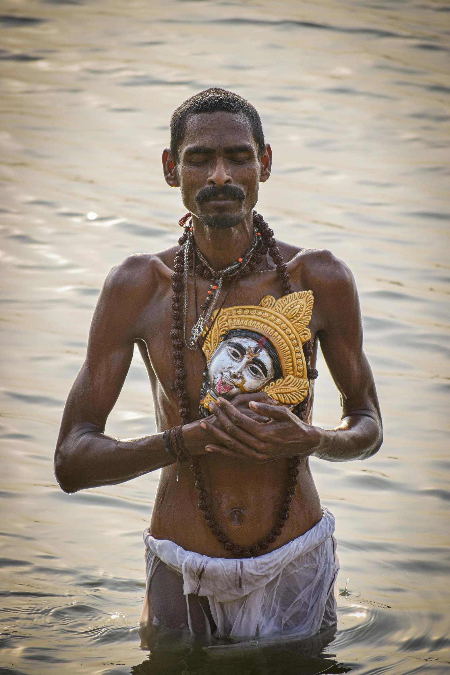 a man in the water holding a mask