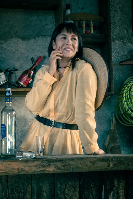 a woman leaning against a bar smiling at the camera