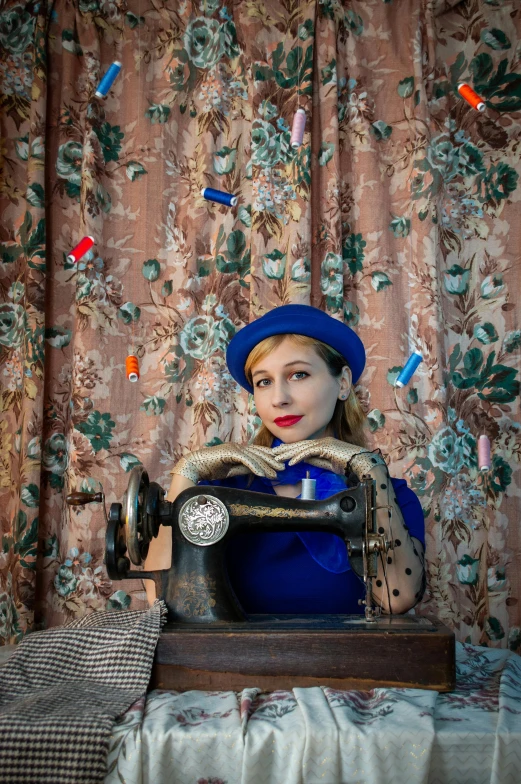 a woman is sitting in front of an old sewing machine